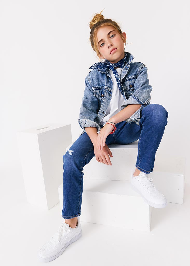kudro kids destroy skinny jean full shot on girl model siting on white apple boxes