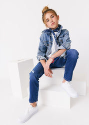 kudro kids destroy skinny jean full shot on girl model siting on white apple boxes