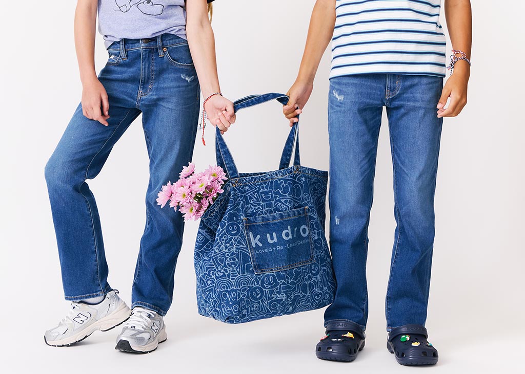 The Tote Kudro Kids tote bag made from sustainable denim with purple flowers and models wearing destroy straight jeans