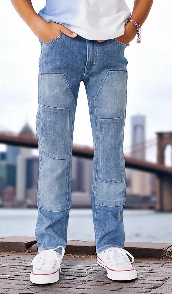 Person wearing light blue jeans with patches standing by a waterfront with a Brooklyn bridge in the background.