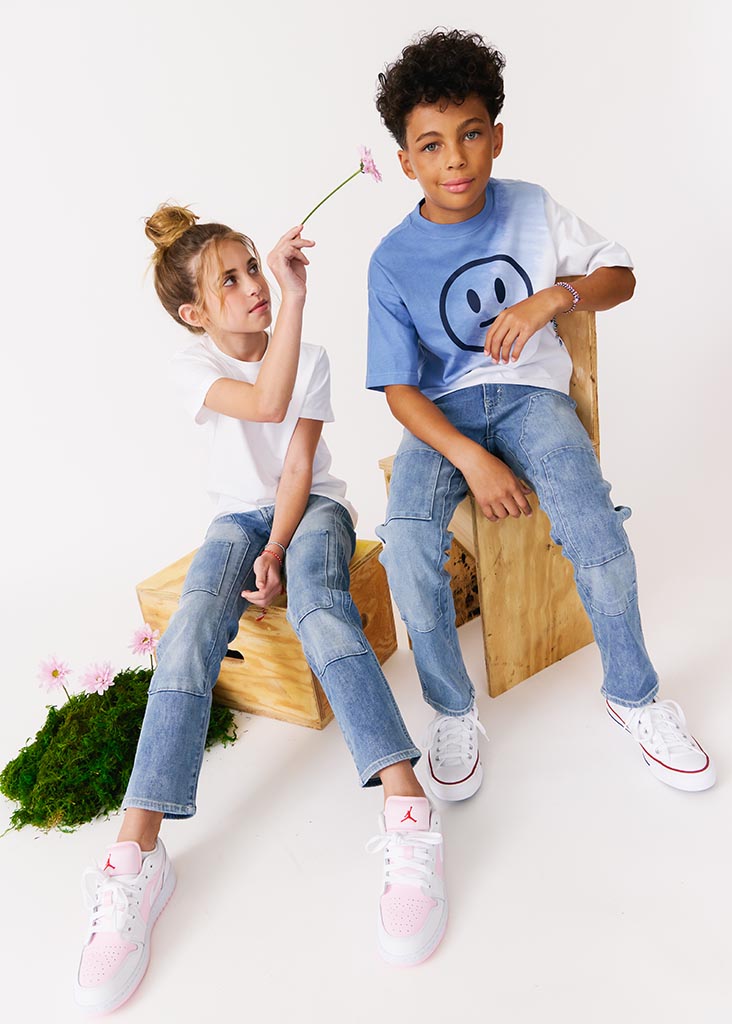 kudro kids utility straight boy and girl siting on wooden apple boxes with flowers