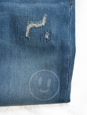 Close-up of blue denim fabric with a brand logo on a white background