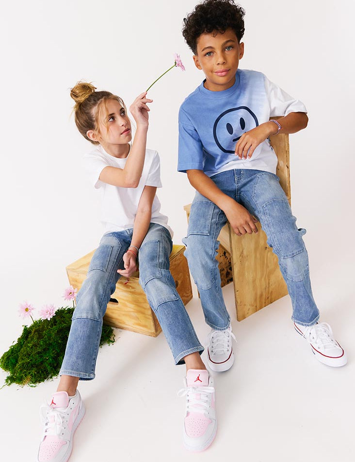 kudro kids utility straight boy and girl siting on wooden apple boxes with flowers